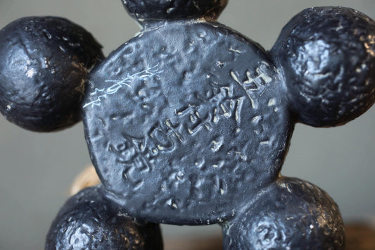 a close-up view of a black, textured surface with some writing or markings on it.