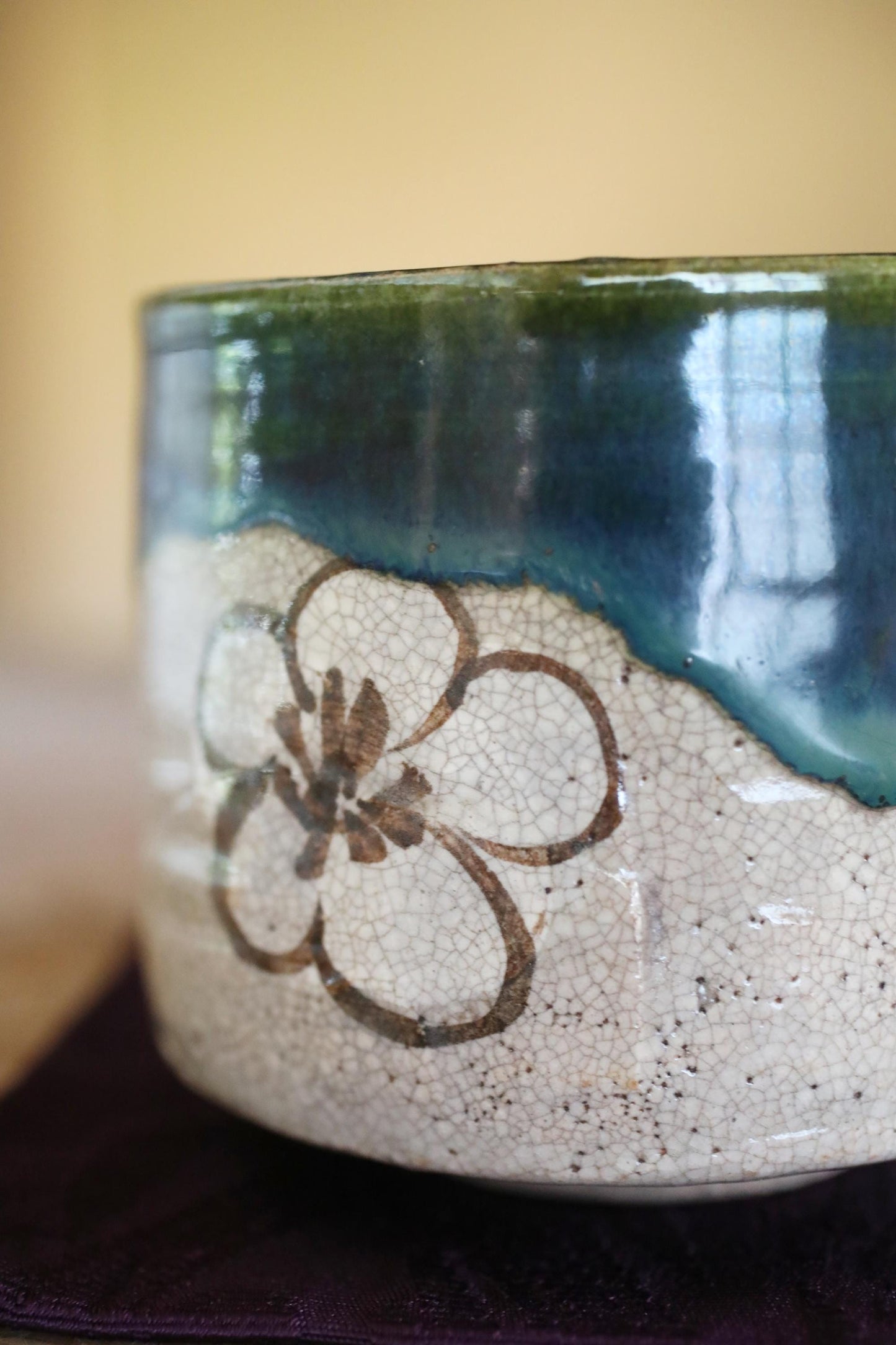 A ceramic vase with a floral design on it, sitting on a surface.