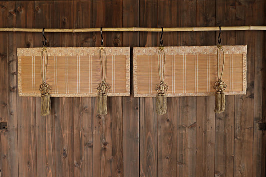 a pair of wooden blinds hanging on a wooden wall, each with a tassel hanging from the top.