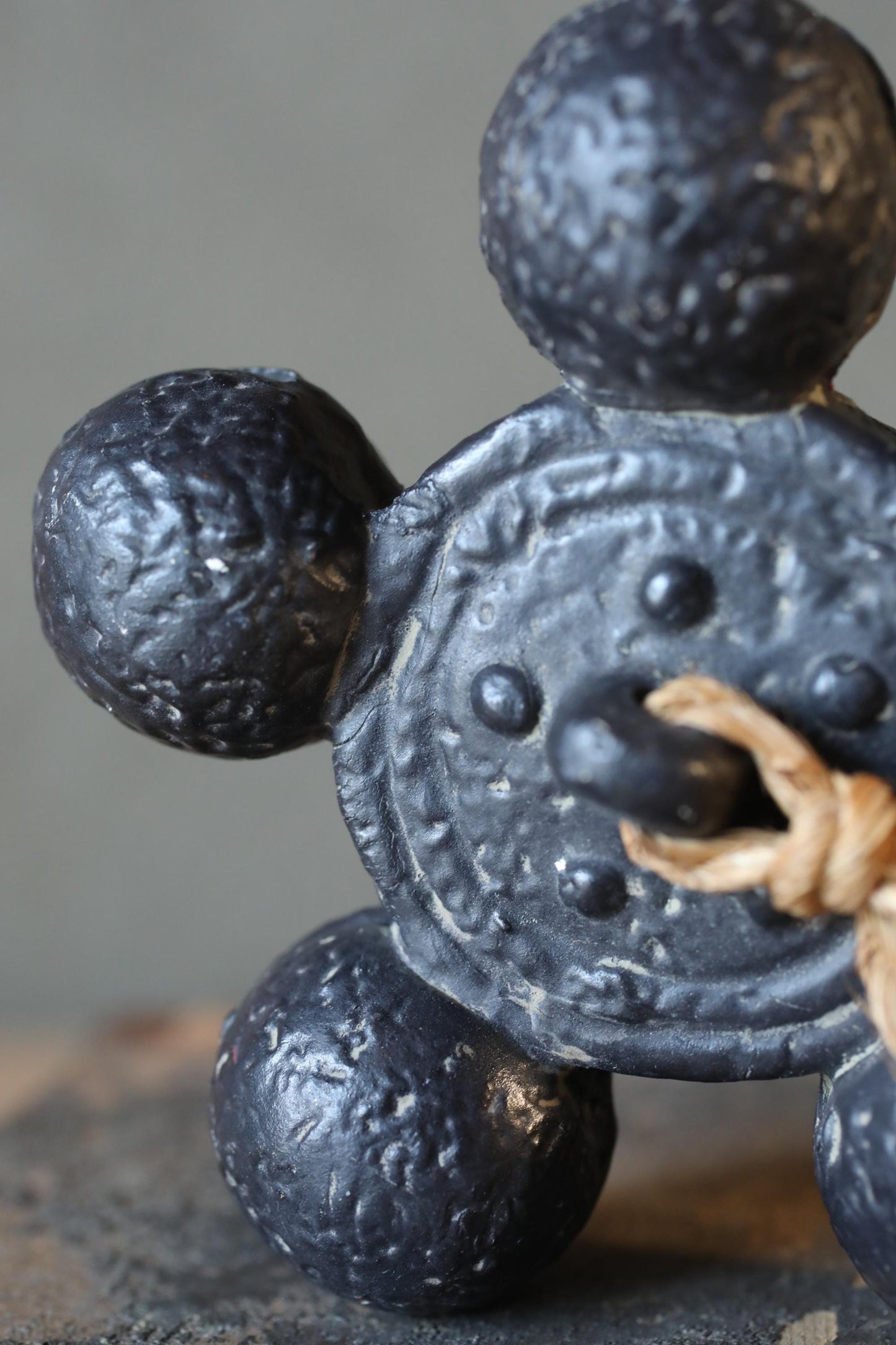 A close-up image of a black metal object with a circular design, featuring three large balls and a smaller ball at the center.