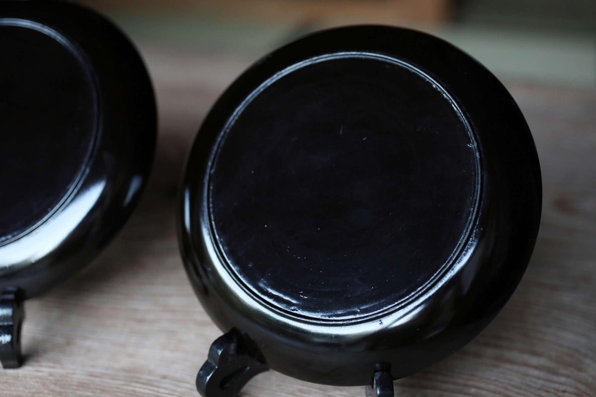 a close-up view of a black ceramic bowl or dish, with a dark background.