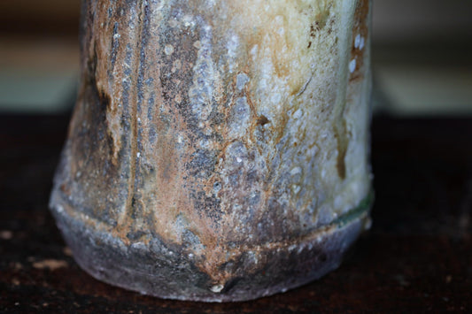 A close-up view of a weathered, rusted metal object with a textured, aged appearance.
