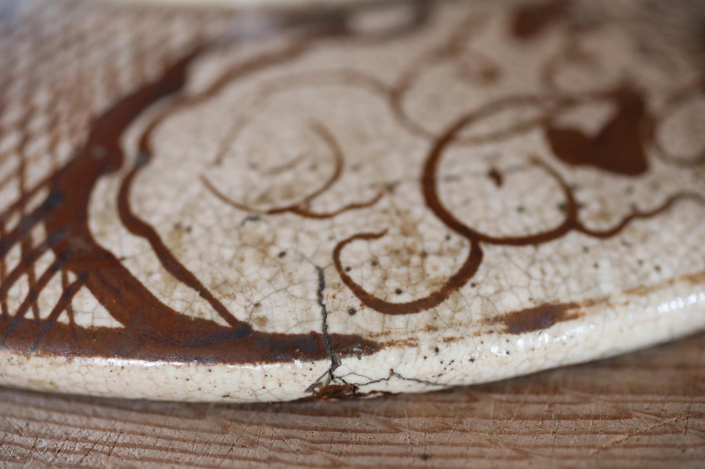 A close-up image of a ceramic or porcelain object with a pattern or design on its surface, featuring a mix of brown and white colors.