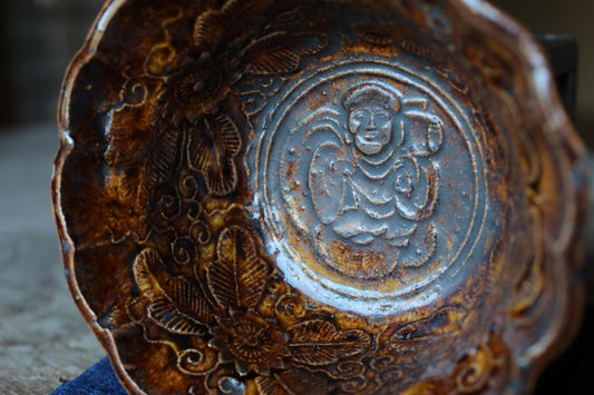 a close-up view of a decorative bowl with intricate floral and leaf patterns.
