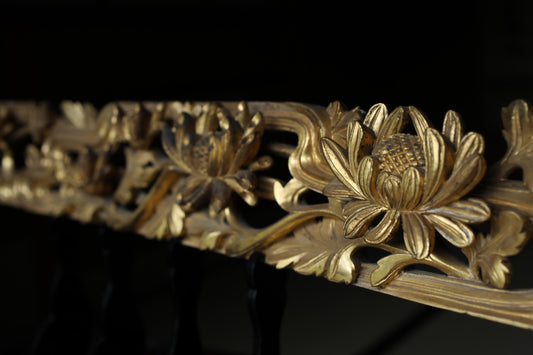 a close-up view of a decorative gold-colored metal railing with intricate floral designs.