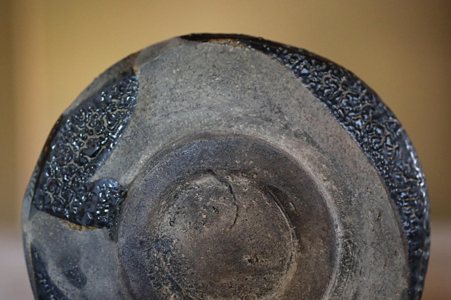 a close-up view of a black, textured ceramic object with a dark, glossy finish.