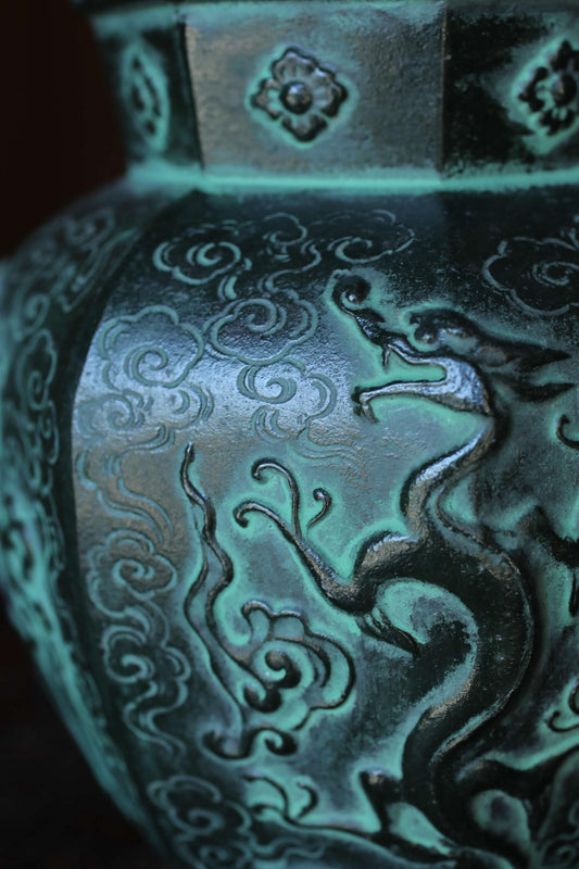 a close-up view of a decorative vase with intricate patterns and designs, including a dragon motif.