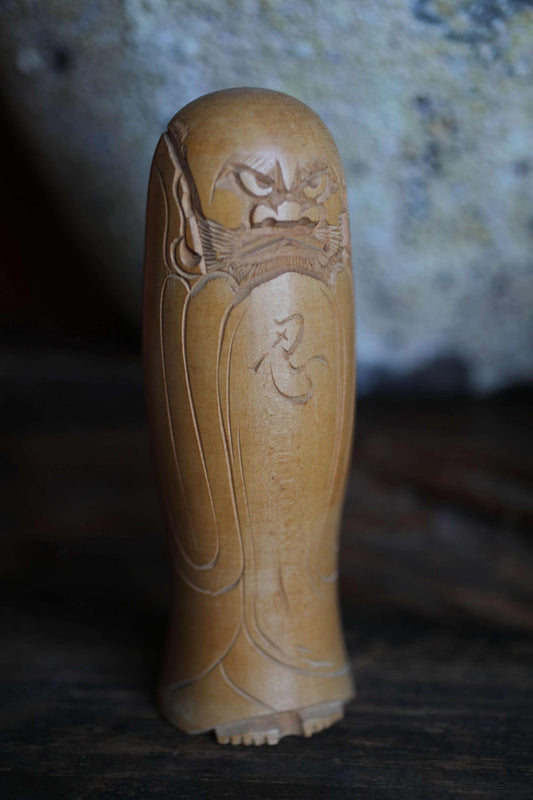 A wooden statue of a deity or religious figure, carved with intricate details and a prominent headdress.