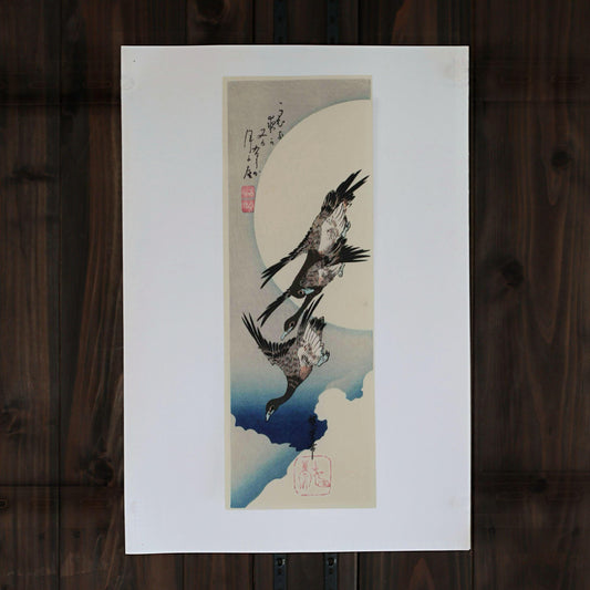 The image is a framed artwork depicting a pair of birds in flight, with a large white circle in the background.