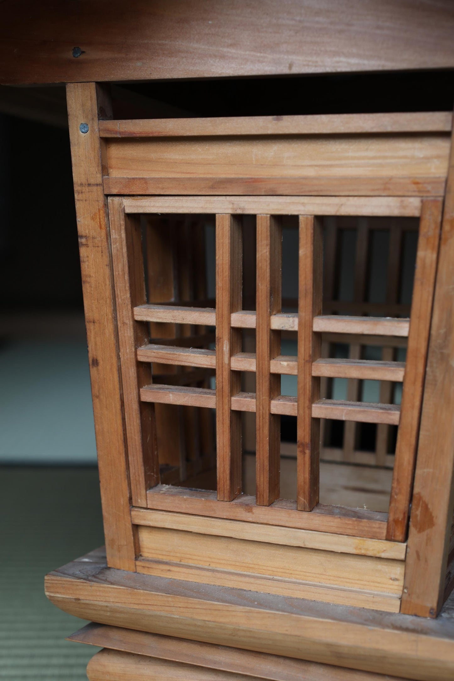a close-up view of a wooden structure with a lattice-like design, featuring a grid-like pattern of wooden slats.