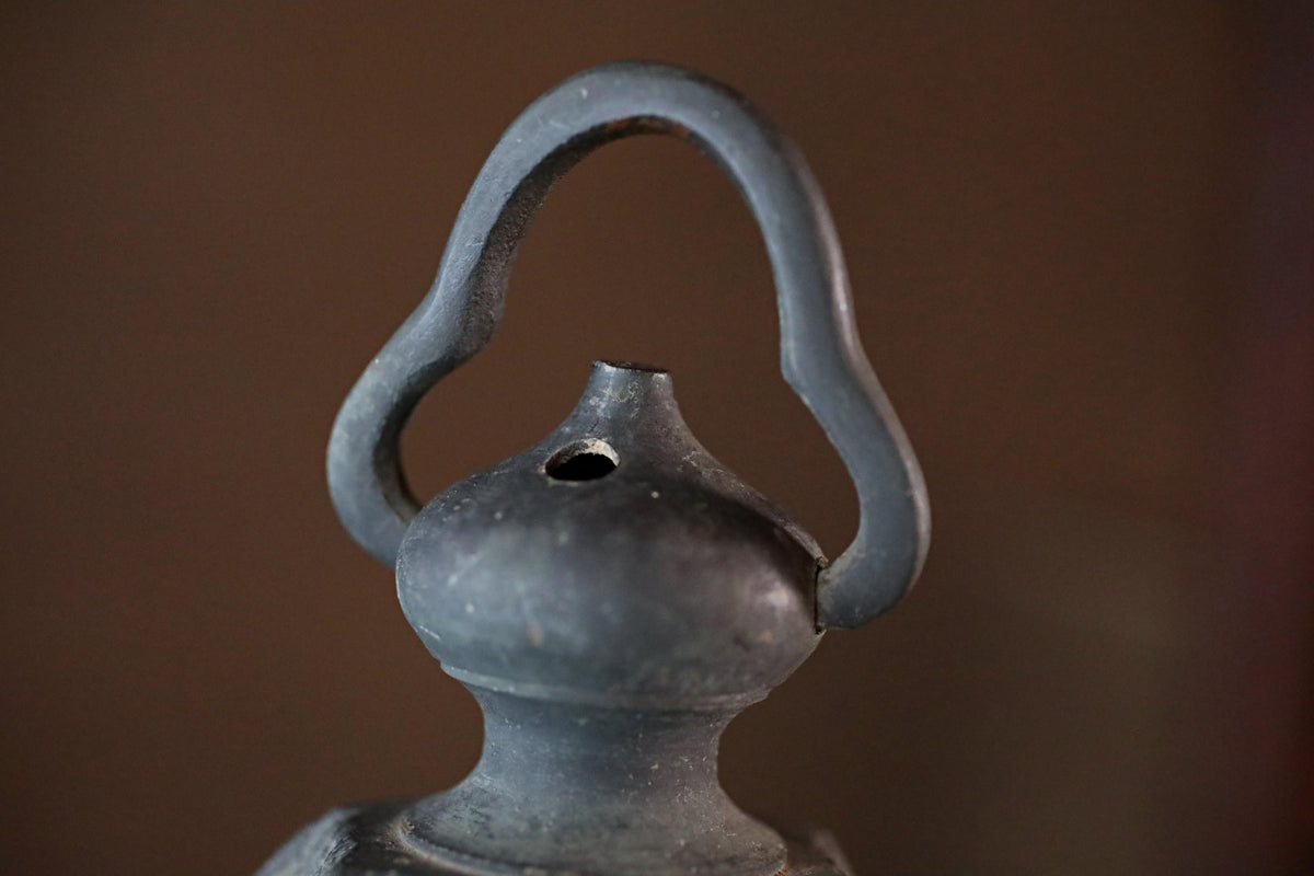A close-up view of a metal object with a curved handle, possibly a piece of furniture or a decorative item.