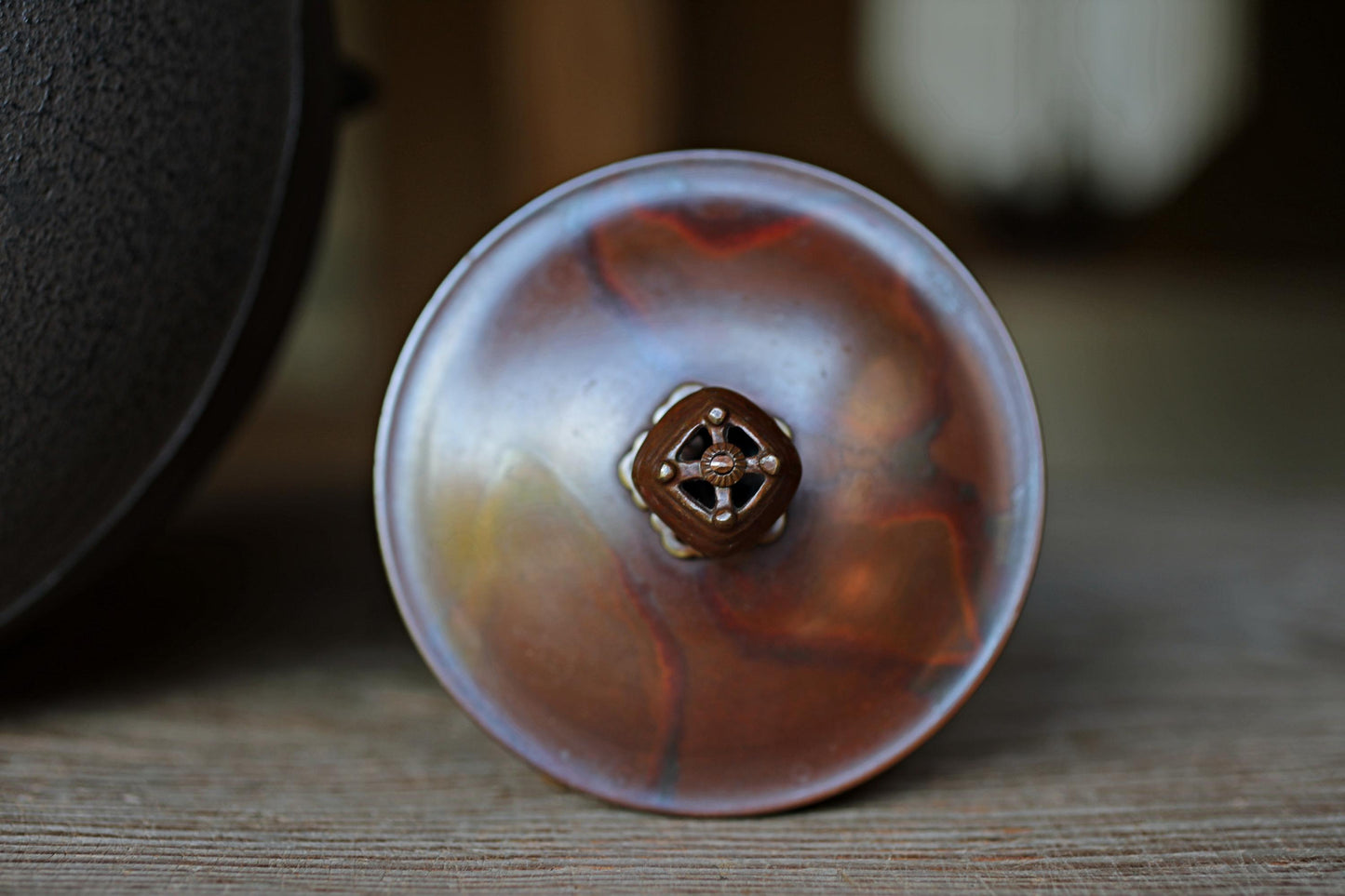 a close-up view of a metal object with a unique, marbled pattern, possibly a piece of pottery or a decorative item.