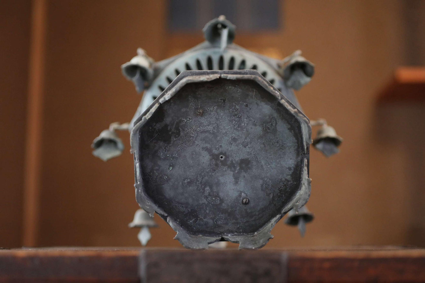 a close-up view of a metal object, possibly a piece of art or a decorative item, with a textured surface and a circular shape.