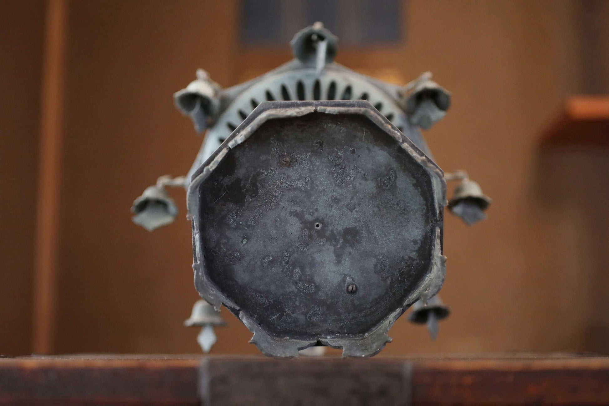 a close-up view of a metal object, possibly a piece of art or a decorative item, with a textured surface and a circular shape.