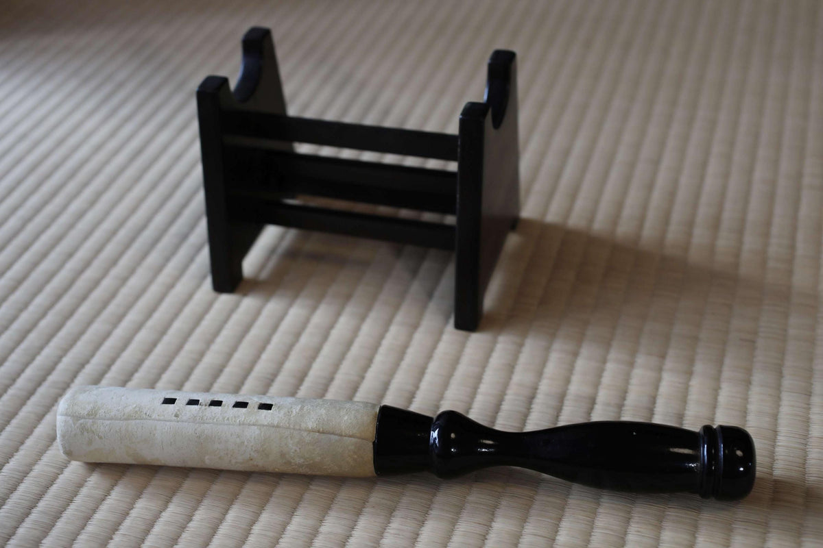 a black and white object, possibly a tool or instrument, resting on a textured surface.