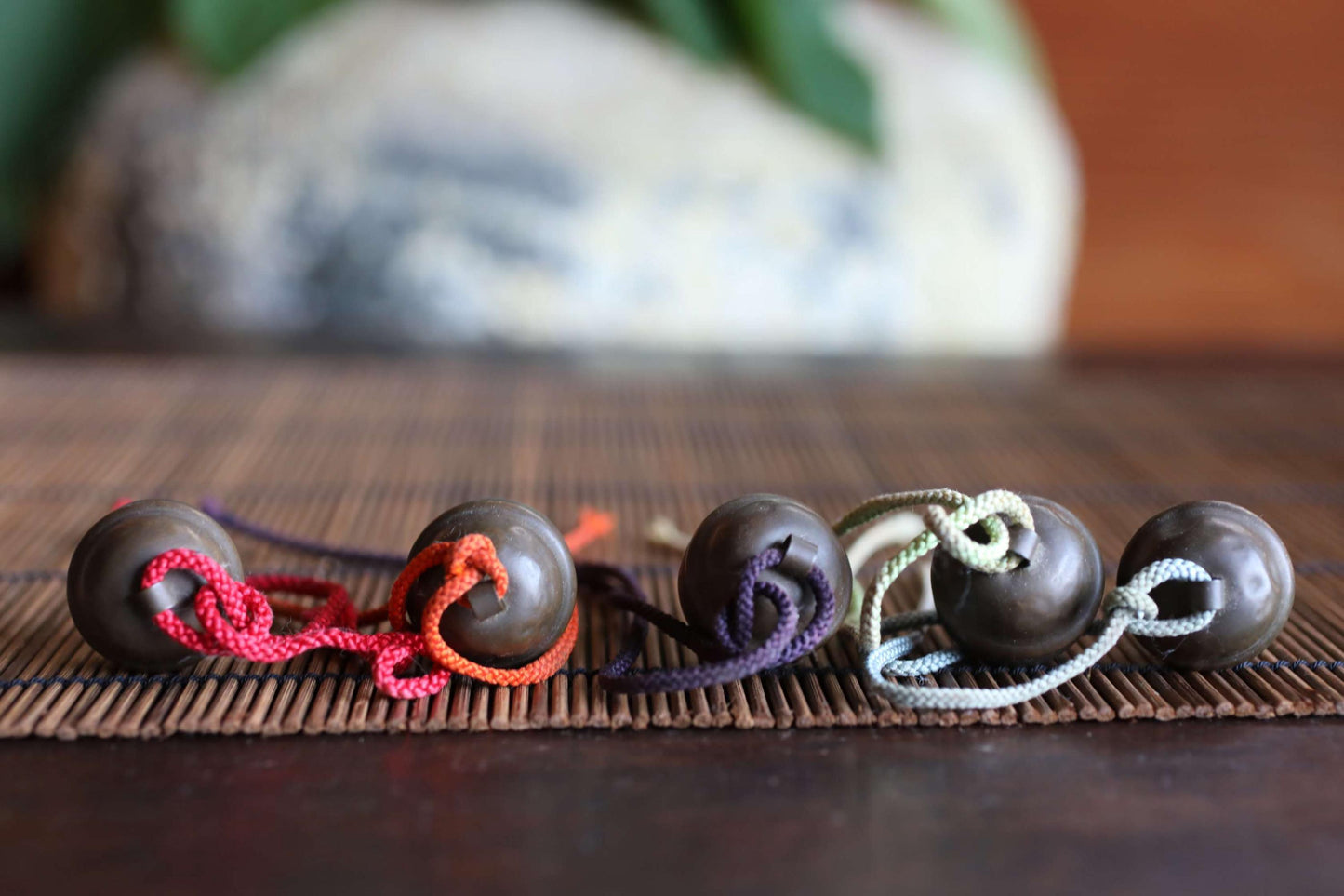 a collection of colorful beads or buttons arranged on a wooden surface, with a blurred background.