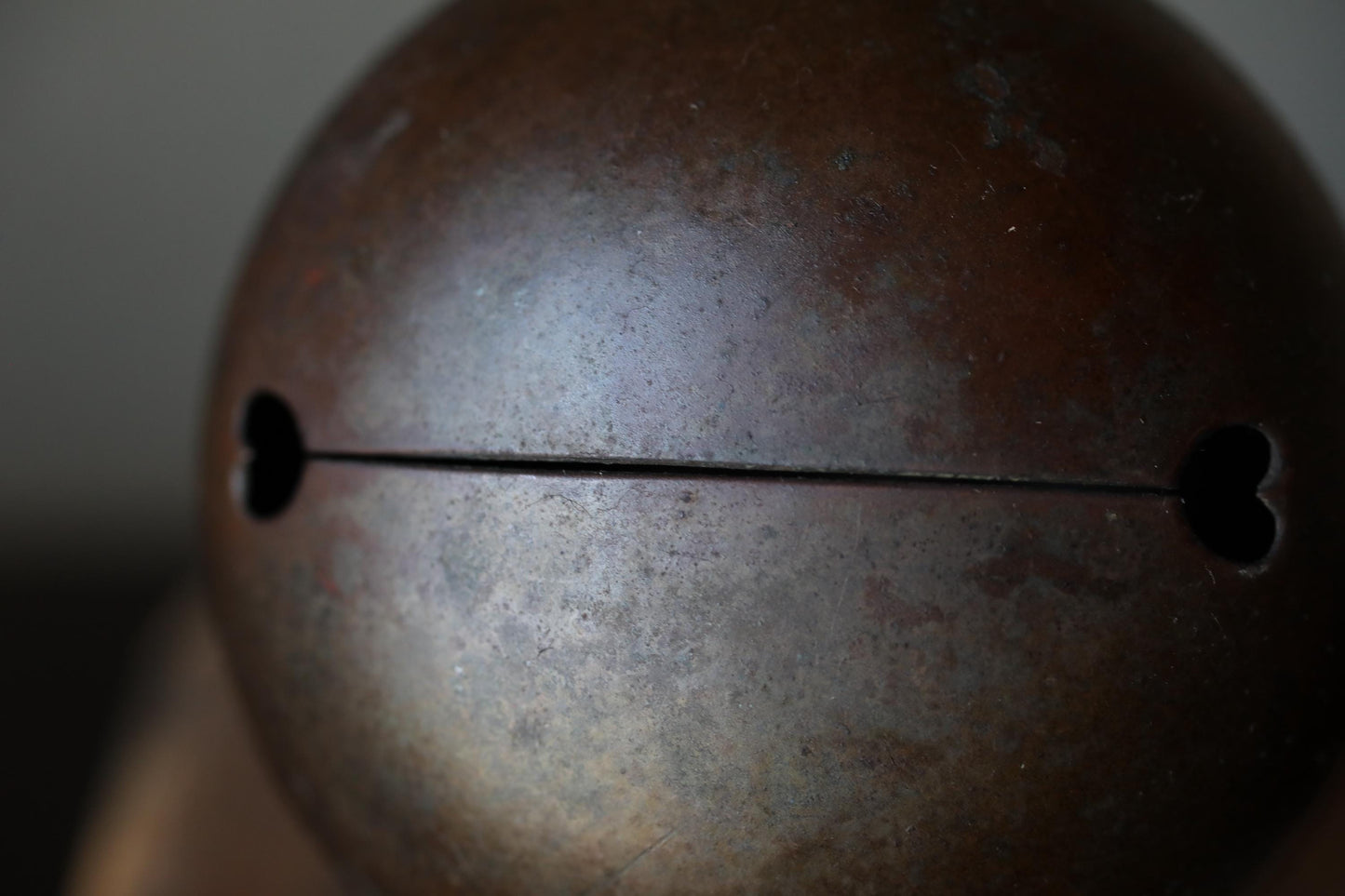 A close-up image of a rusted metal object with a heart-shaped cutout on one side.