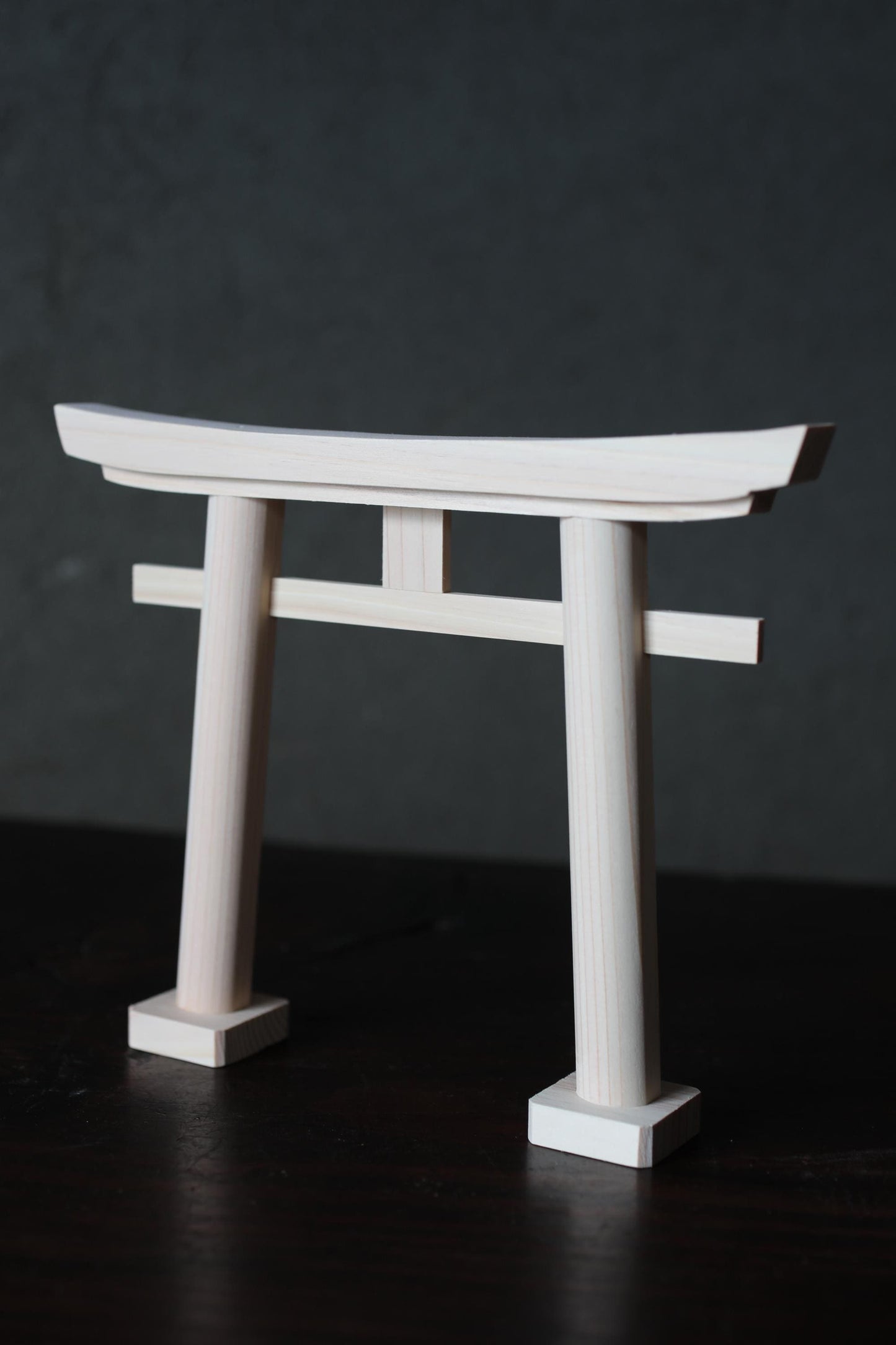 A white wooden gate or gate-like structure stands against a dark background.