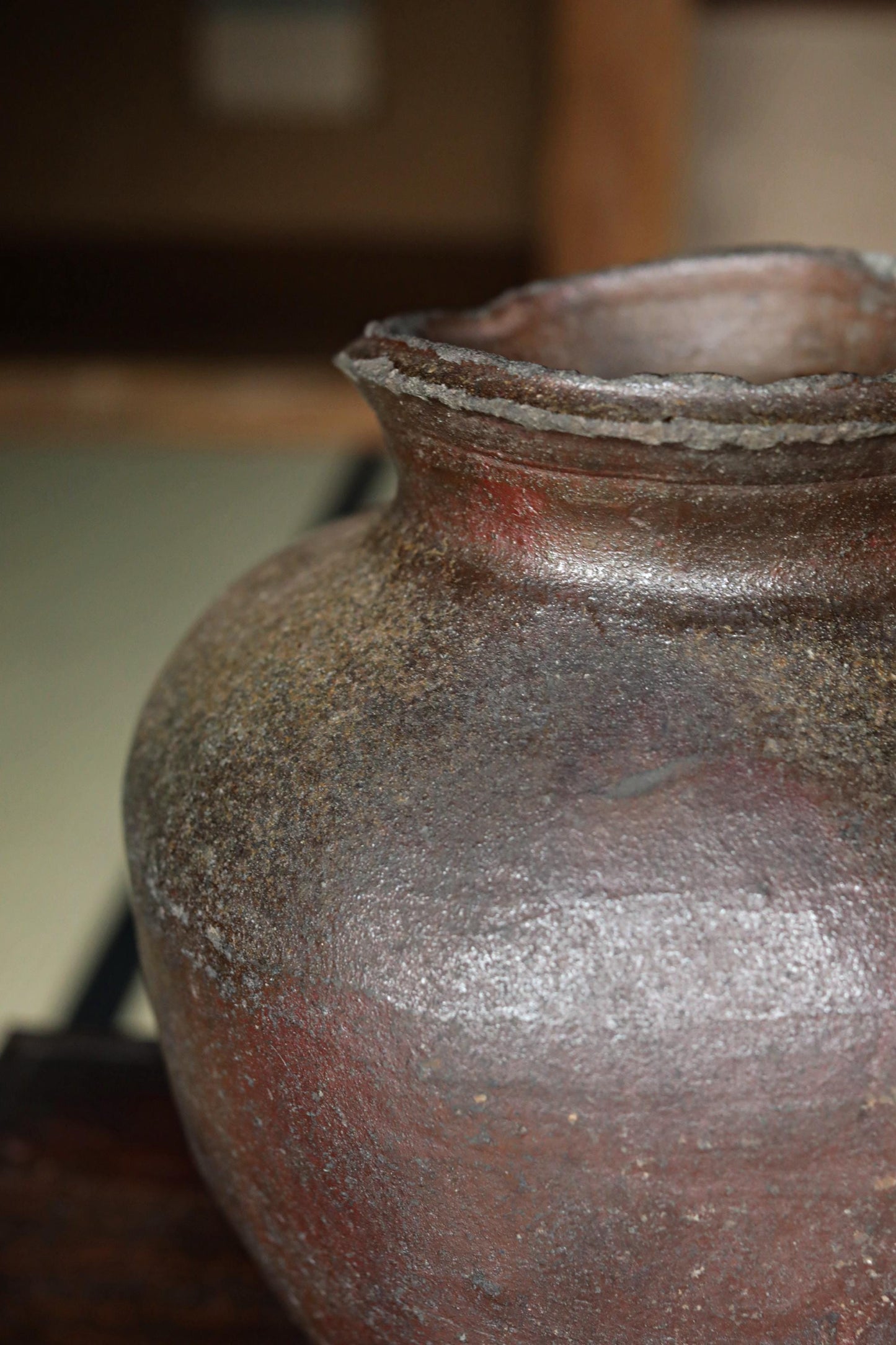 A close-up image of a large, rusted clay vase with a weathered, aged appearance.