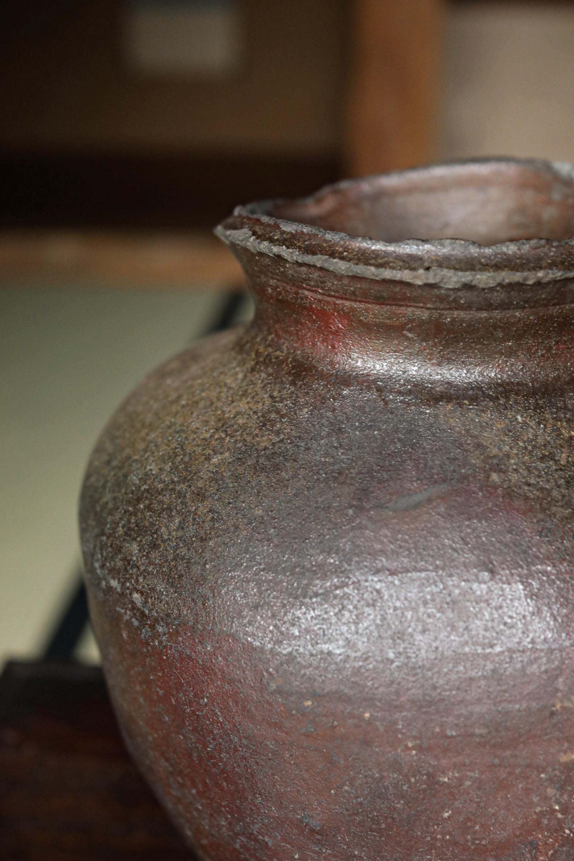 A close-up image of a large, rusted clay vase with a weathered, aged appearance.