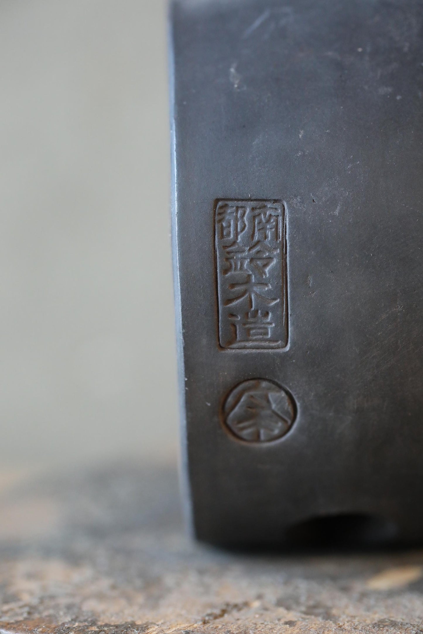 a close-up view of a metal surface with a stamp or emblem featuring Japanese characters and a circular emblem.
