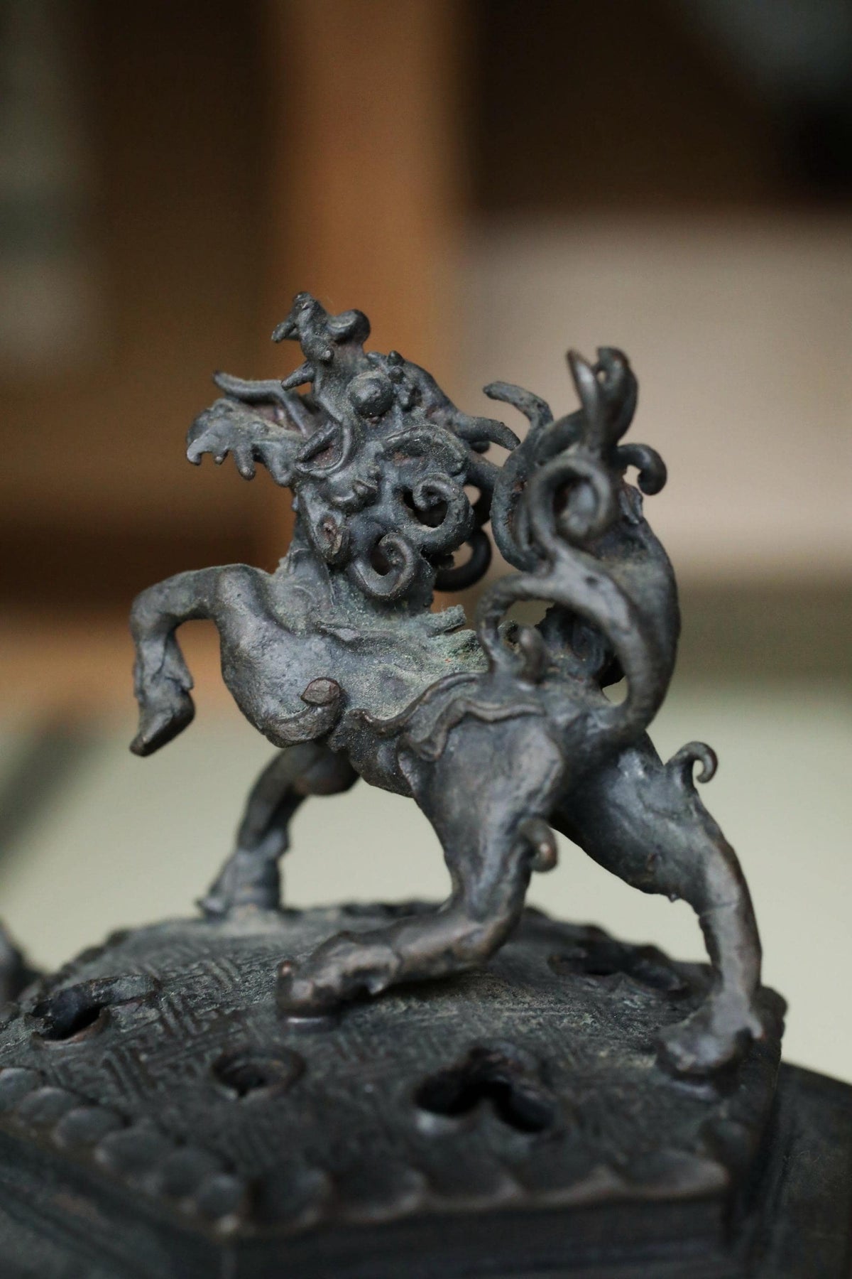 A close-up image of a decorative metal sculpture depicting a mythical creature, possibly a dragon or lion.