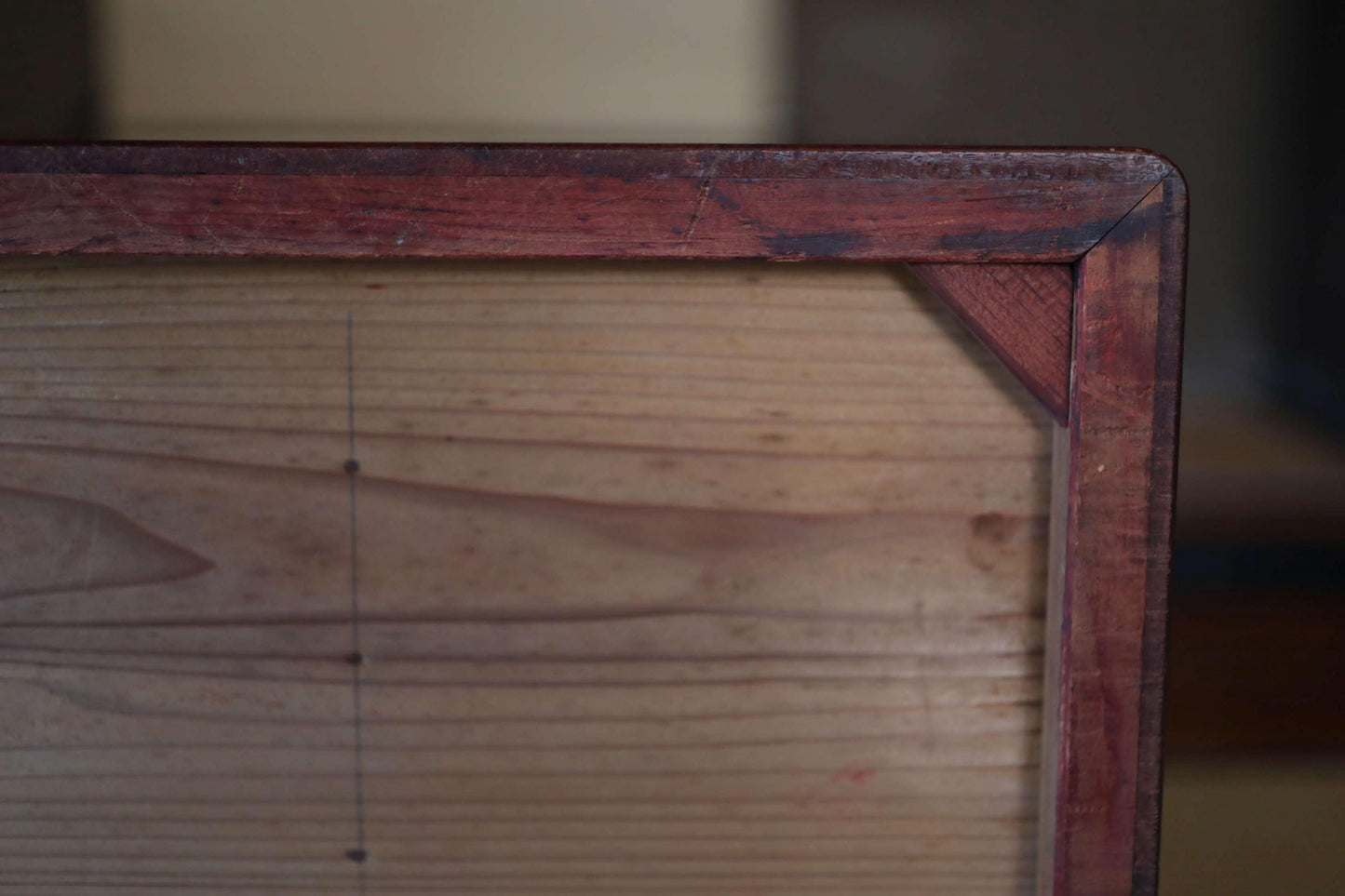 a close-up view of a wooden frame with a dark finish, likely made of wood.