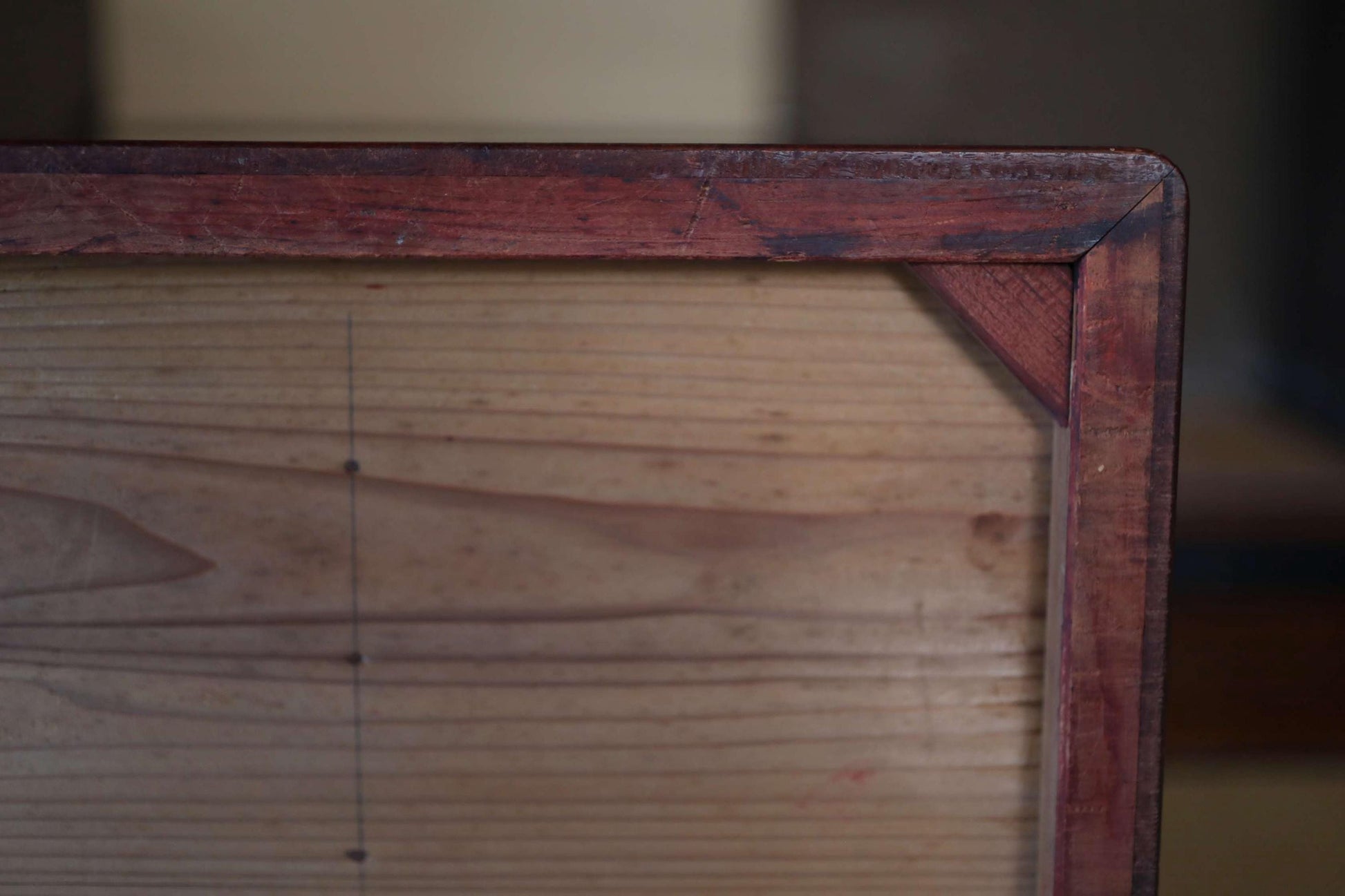 a close-up view of a wooden frame with a dark finish, likely made of wood.