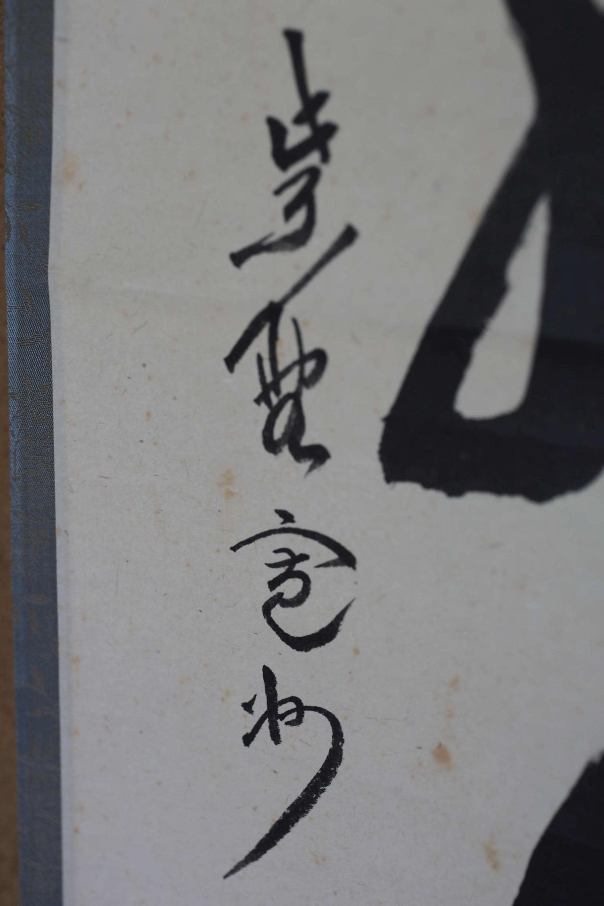 a close-up view of a piece of paper with Chinese characters written on it. The characters are in black ink and appear to be in a vertical orientation. The image does not contain any other objects or text, and the focus is solely on the Chinese characters.