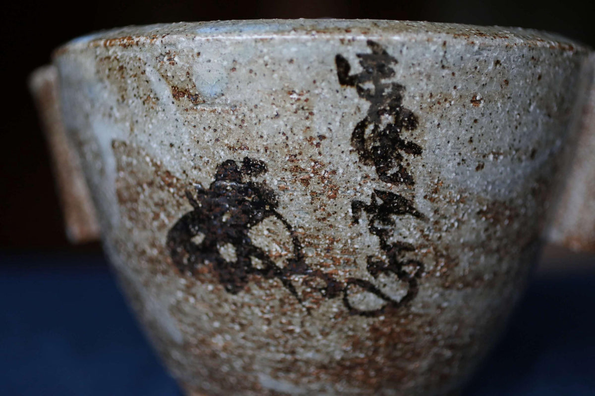 A close-up image of a ceramic bowl with a black design on its surface.