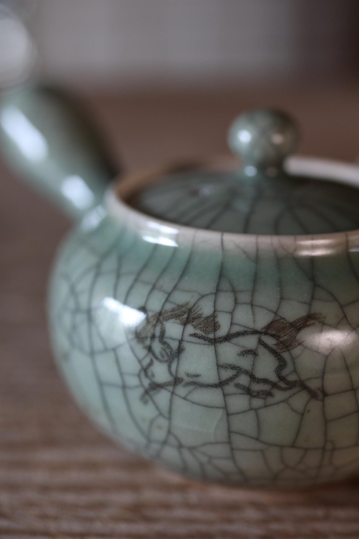 A close-up image of a ceramic teapot with a textured, cracked appearance.