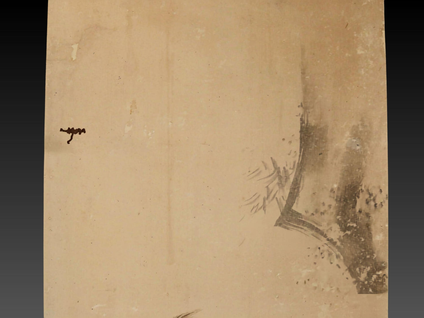 The image is a simple, textured surface with a small, dark object or symbol in the top left corner.