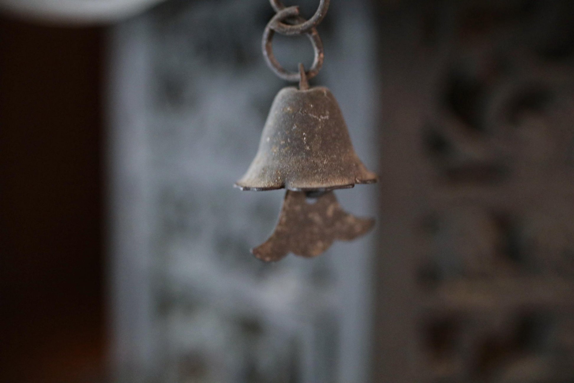 An old, rusted bell hanging from a chain.