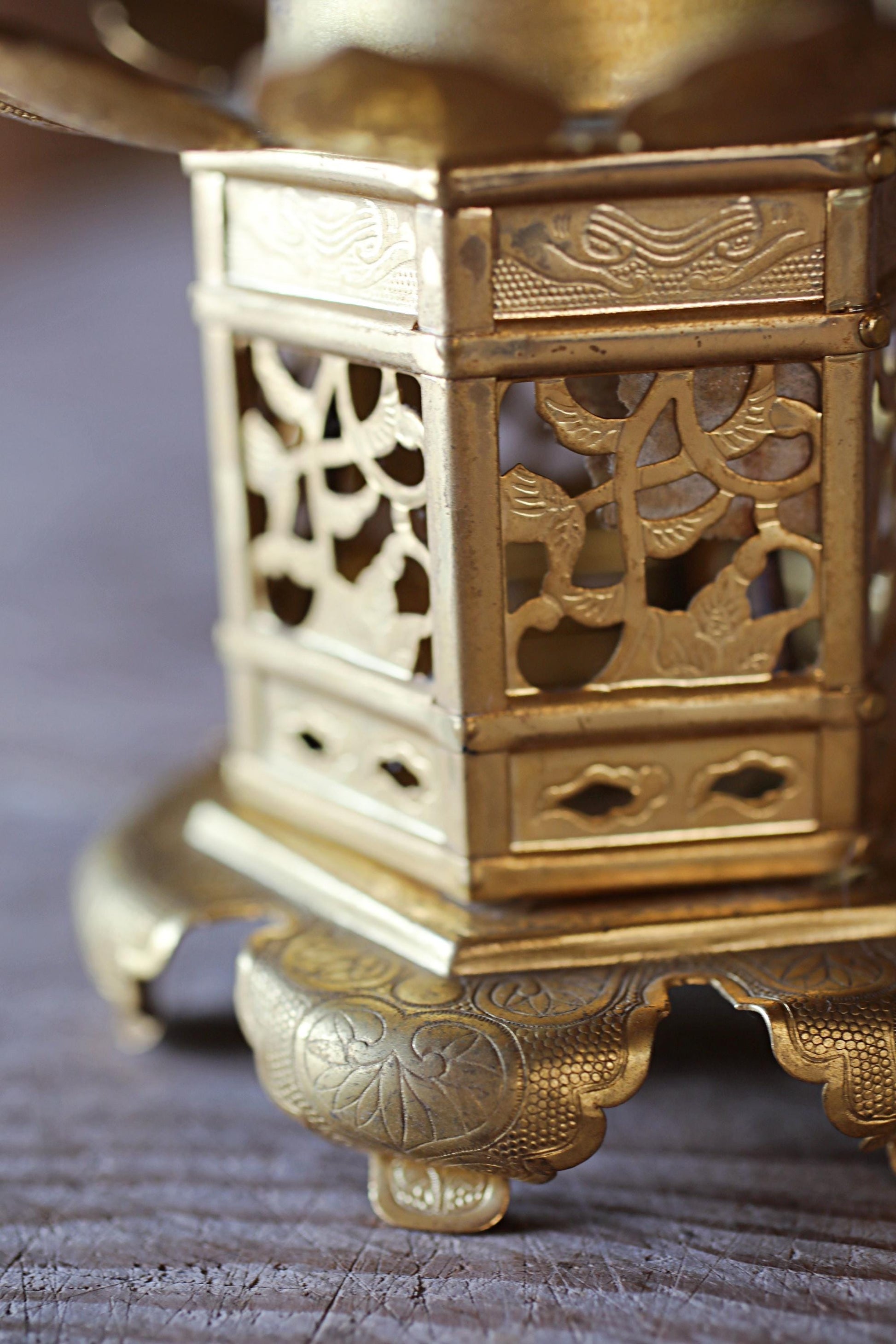 A close-up view of a decorative golden object, possibly a vase or sculpture, with intricate patterns and designs.