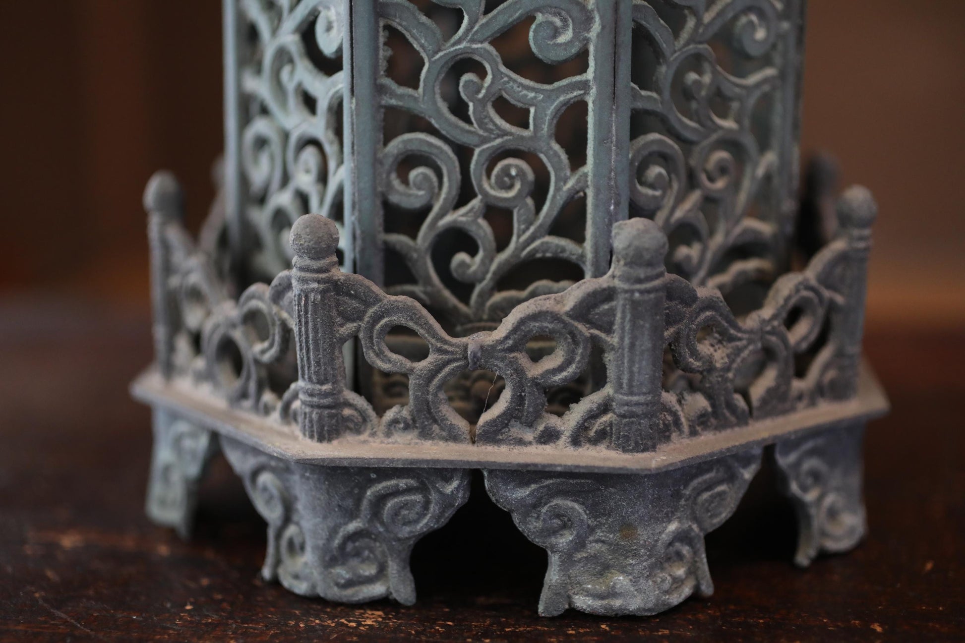 a close-up view of an ornate, intricately designed metal object, possibly a decorative piece or a sculpture. The object has a detailed, sculptural design with a lot of curves and patterns, giving it a visually striking appearance.