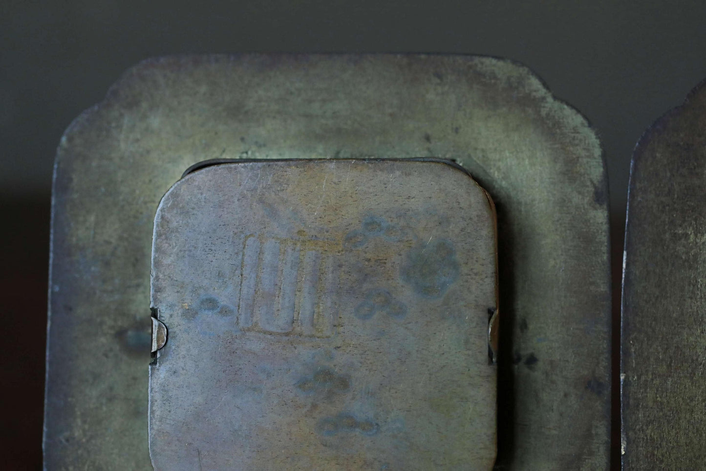 a close-up view of a metal surface with a textured, weathered appearance.