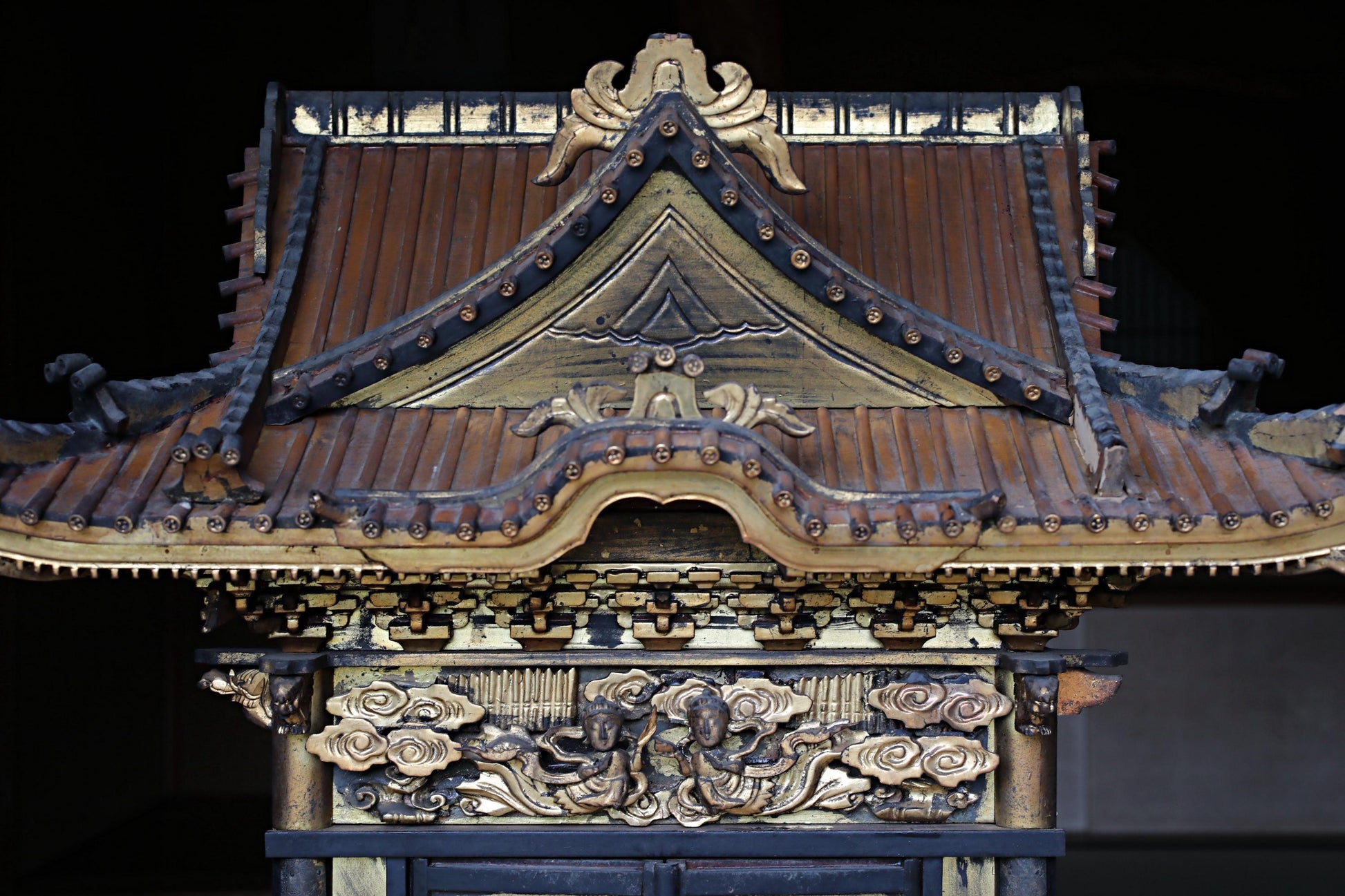 a traditional Japanese temple with intricate carvings and decorations, including a pointed roof and ornate details.