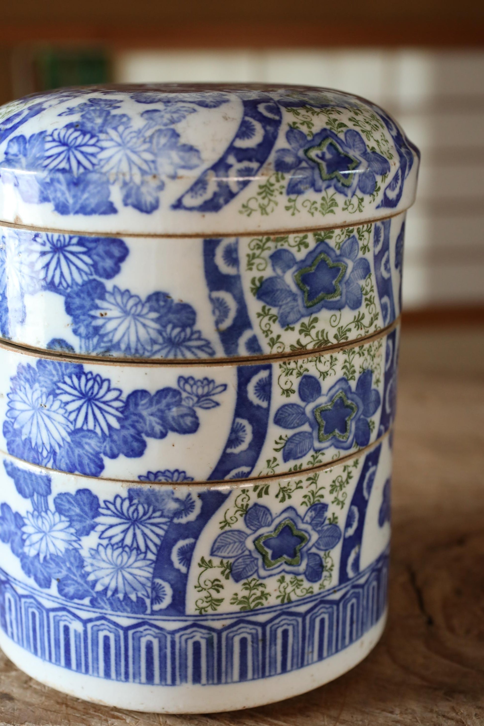 A decorative ceramic container with a blue and white floral pattern, featuring a three-dimensional design with a curved top and sides.