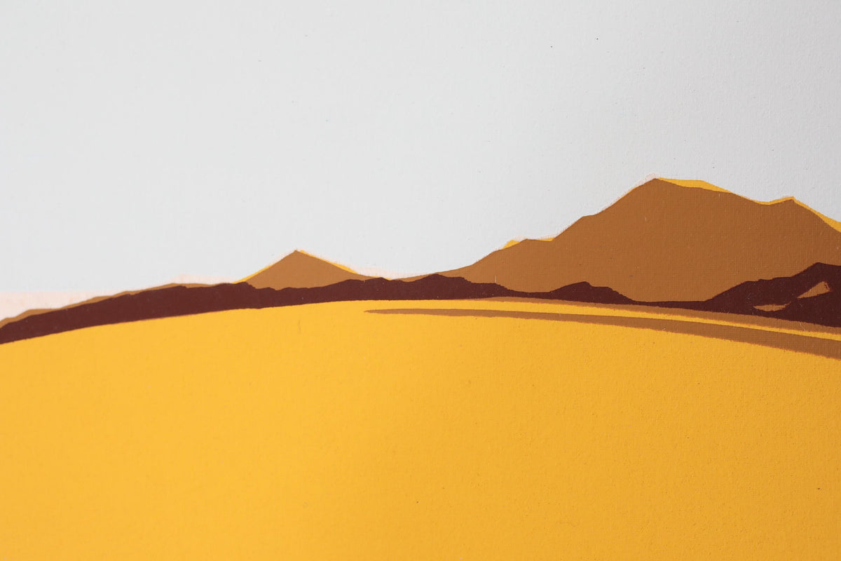 a serene landscape with a vast, golden field stretching out towards a majestic mountain range in the distance.