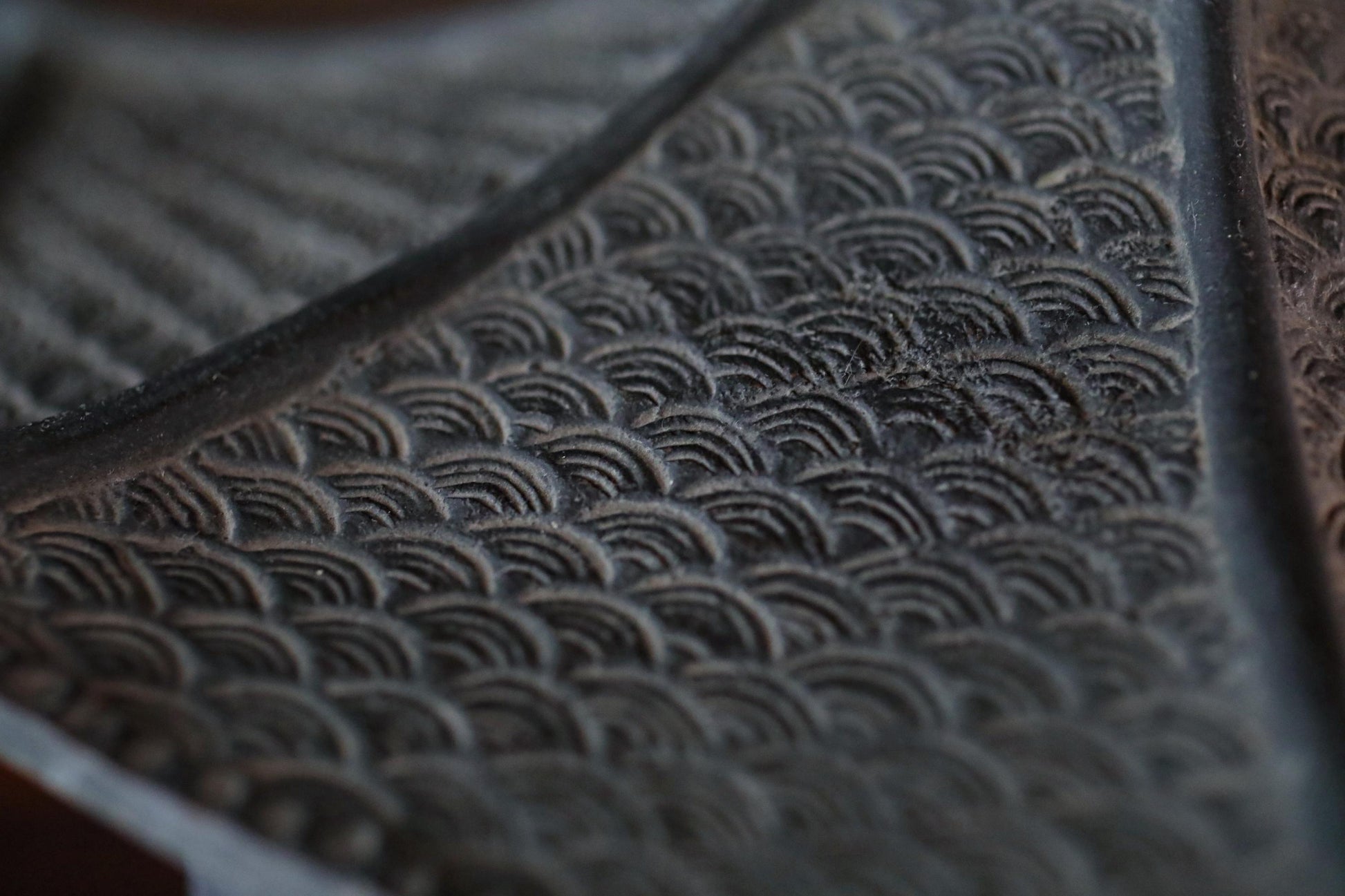 a close-up view of a textured surface with a repeating pattern of curved lines, creating a sense of depth and dimension.