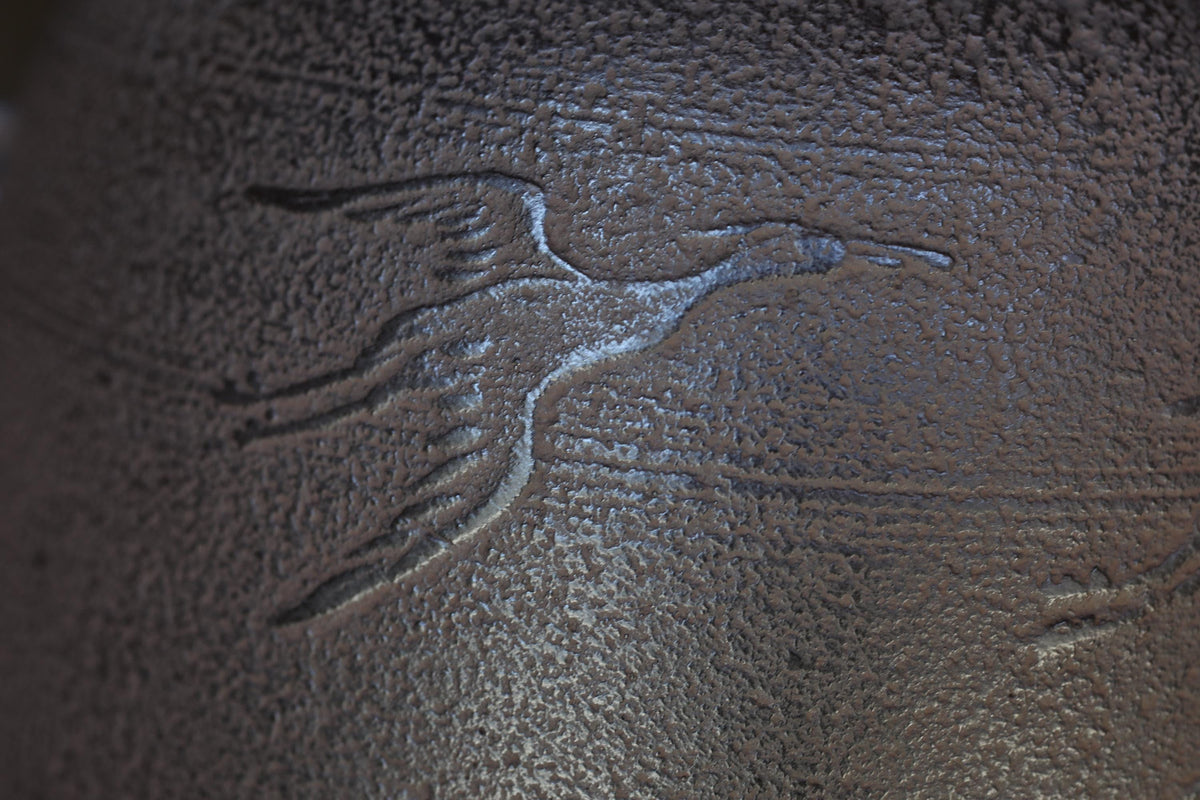 a close-up view of a textured surface with a carved bird-like design.