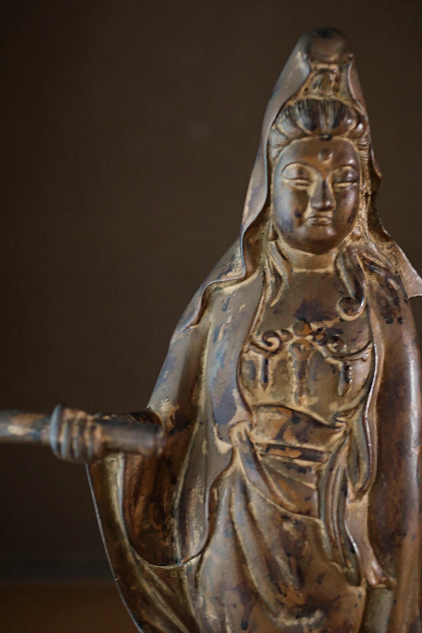 A bronze statue of a deity, possibly a Buddhist figure, with intricate details and a serene expression.