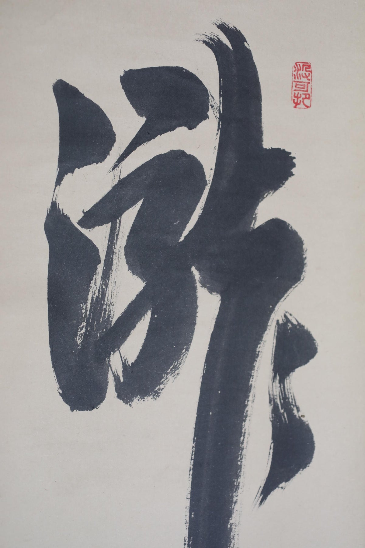a large, abstract black brush stroke on a white background.