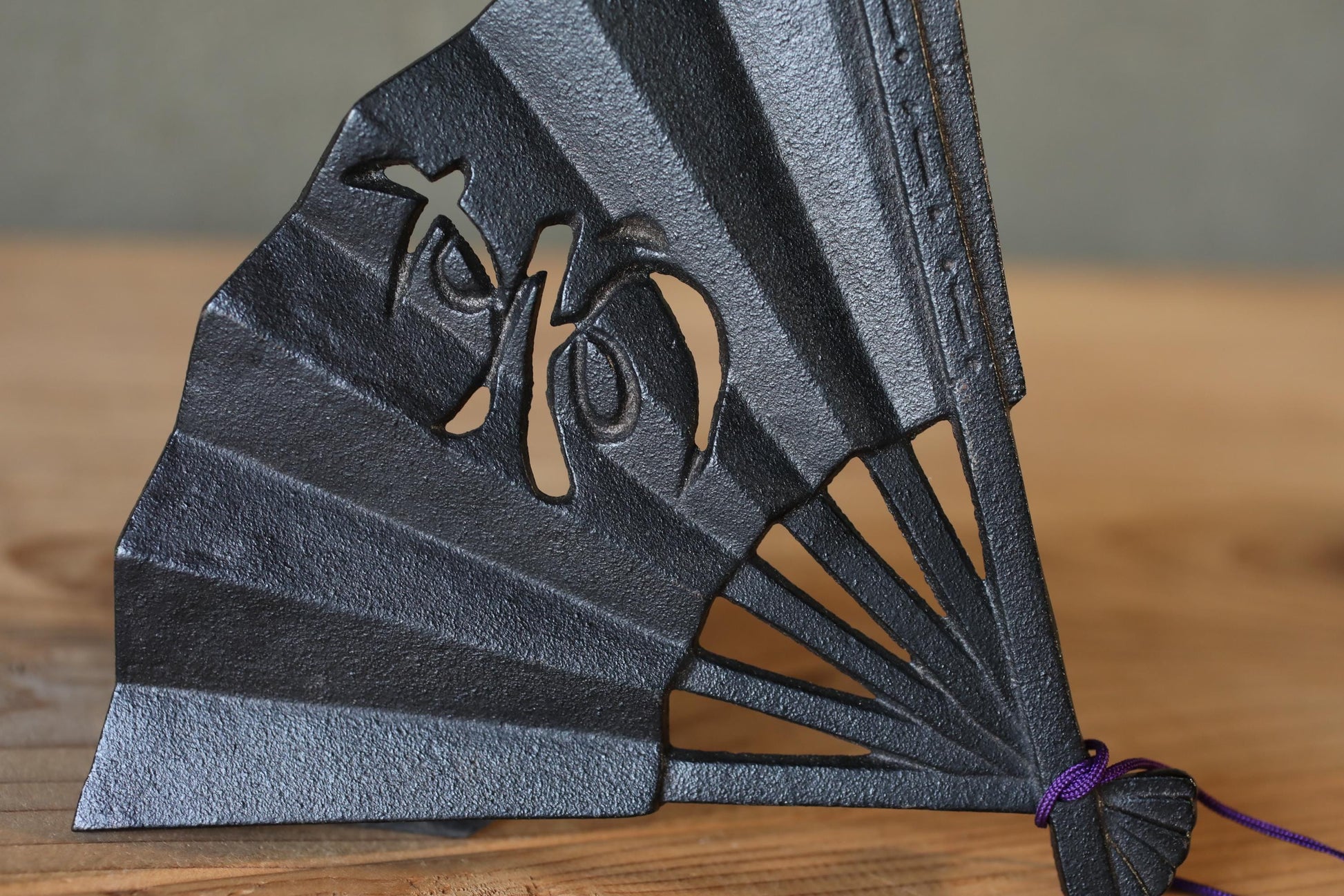 A close-up view of a black metal fan with a decorative design on it.