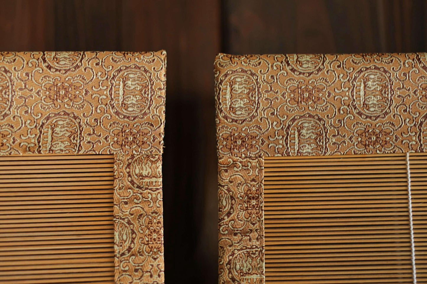 a close-up view of a pair of wooden blinds with a decorative pattern on the top.