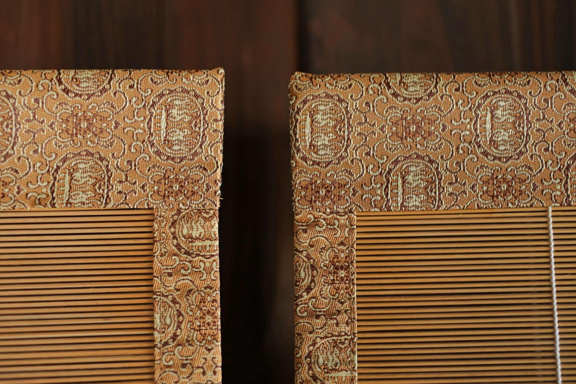 a close-up view of a pair of wooden blinds with a decorative pattern on the top.