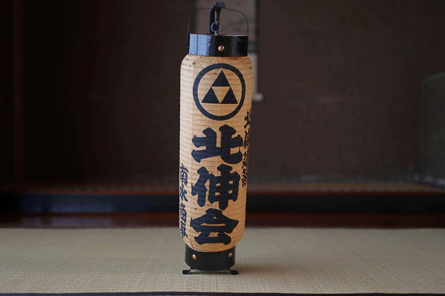 A traditional Japanese paper lantern with a black and white design and Japanese text.