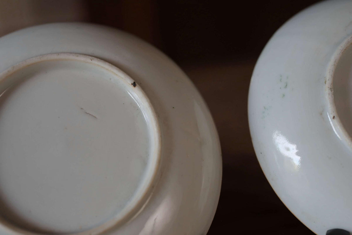 Two white ceramic plates with visible scratches and stains on their surfaces.