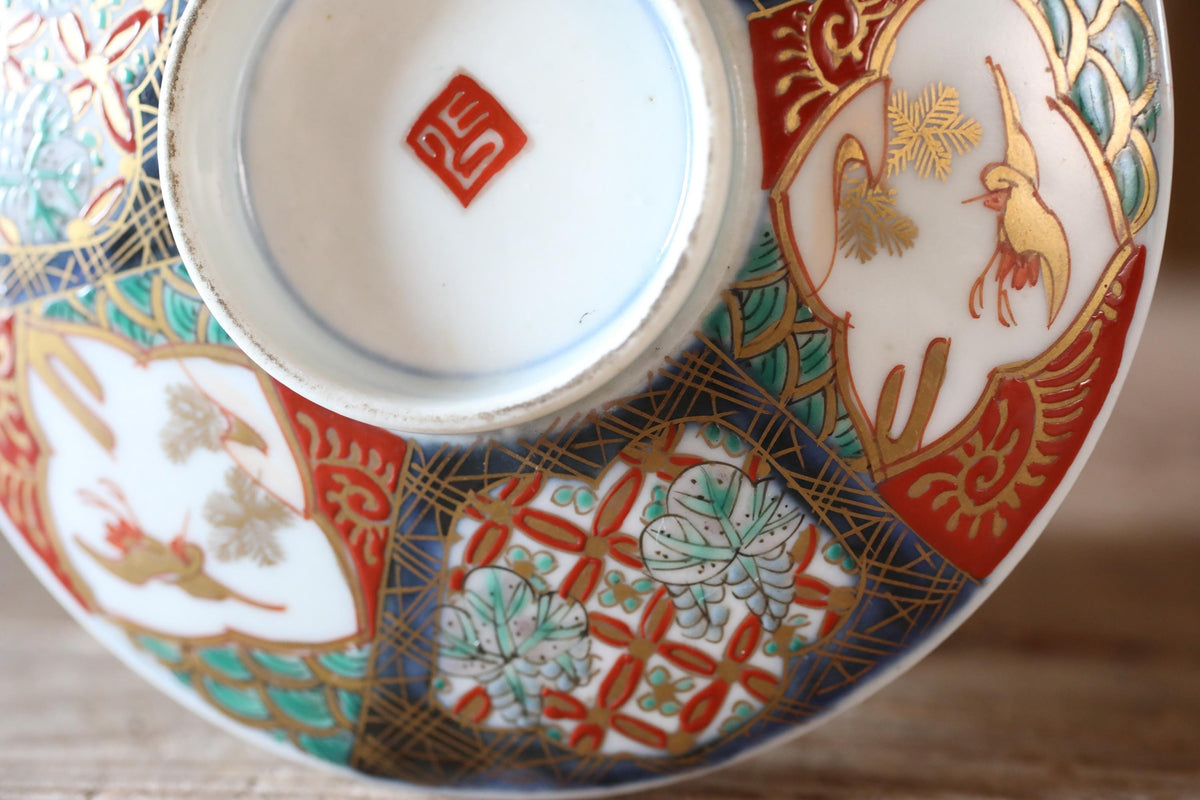 a close-up view of a decorative ceramic dish with intricate patterns and designs, including floral motifs and geometric shapes.