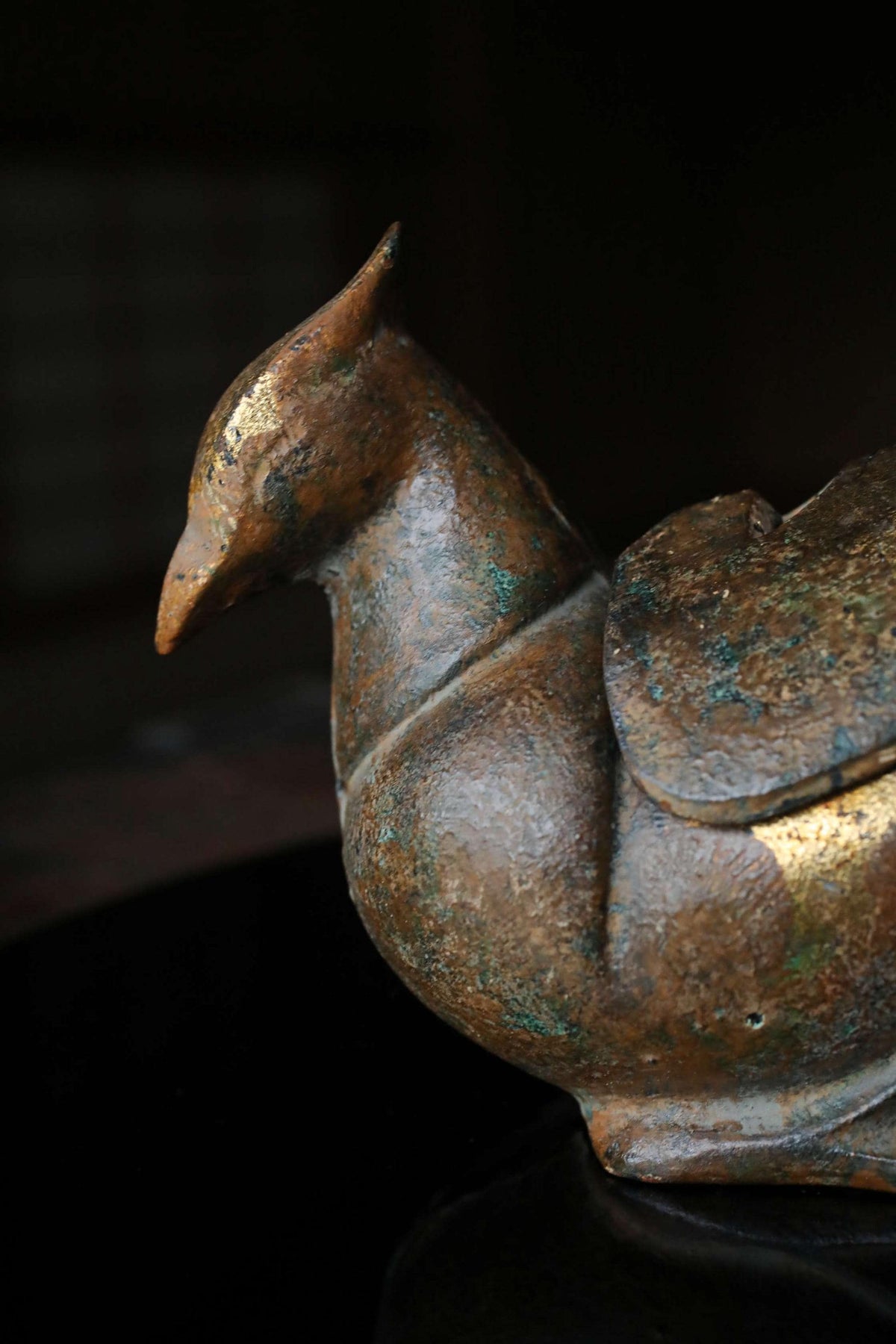 A bronze sculpture of a bird, possibly a phoenix, is shown in the image.
